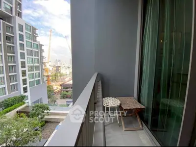 Modern apartment balcony with city view and cozy seating area