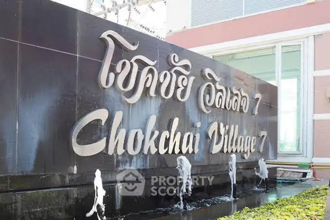 Entrance sign of Chokchai Village 7 with water feature