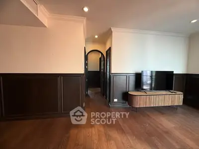 Elegant living room with dark wood paneling and modern TV stand