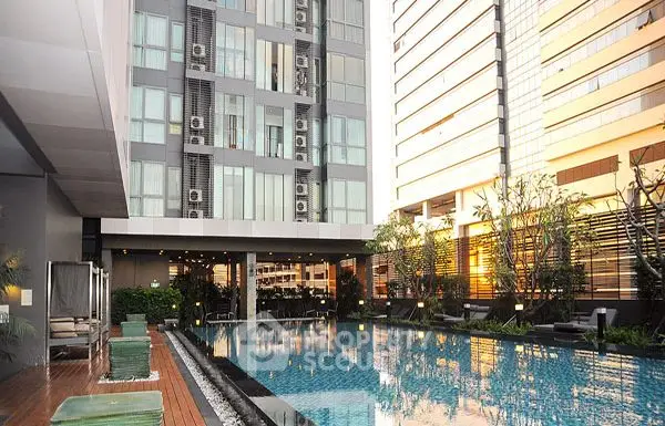 Luxurious modern apartment complex with stunning poolside view at sunset.