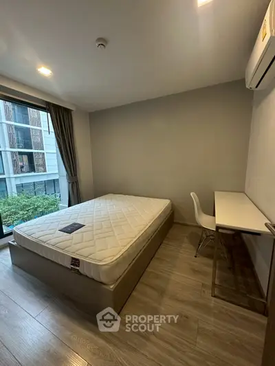 Modern bedroom with large window and minimalist furniture in urban apartment