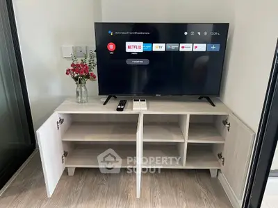 Modern living room with sleek TV stand and smart TV, perfect for entertainment.