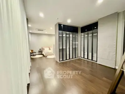 Spacious modern bedroom with elegant walk-in closet and hardwood floors