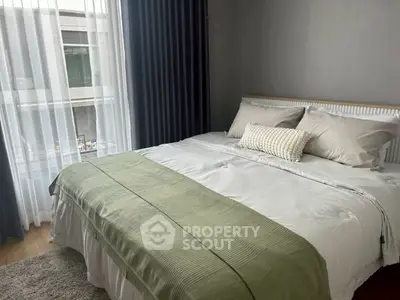 Cozy bedroom with elegant decor and large window for natural light