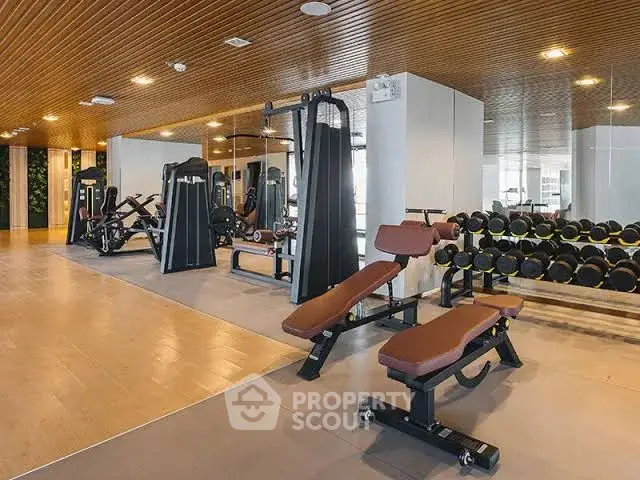 Luxurious gym with modern equipment and mirrored walls in upscale property.