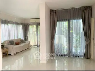 Spacious living room with large windows and elegant curtains in modern home