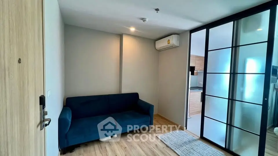 Modern living room with blue sofa and sliding glass doors in a stylish apartment.
