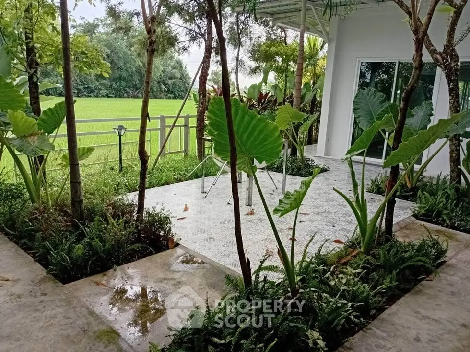 Charming patio with lush greenery and scenic countryside view, perfect for relaxation and outdoor gatherings.