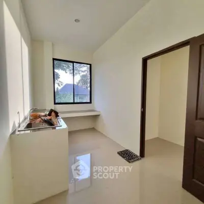 Bright kitchen with large window and sleek countertops in modern home