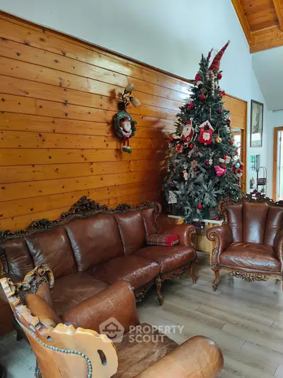 Cozy living room with elegant leather furniture and festive Christmas tree