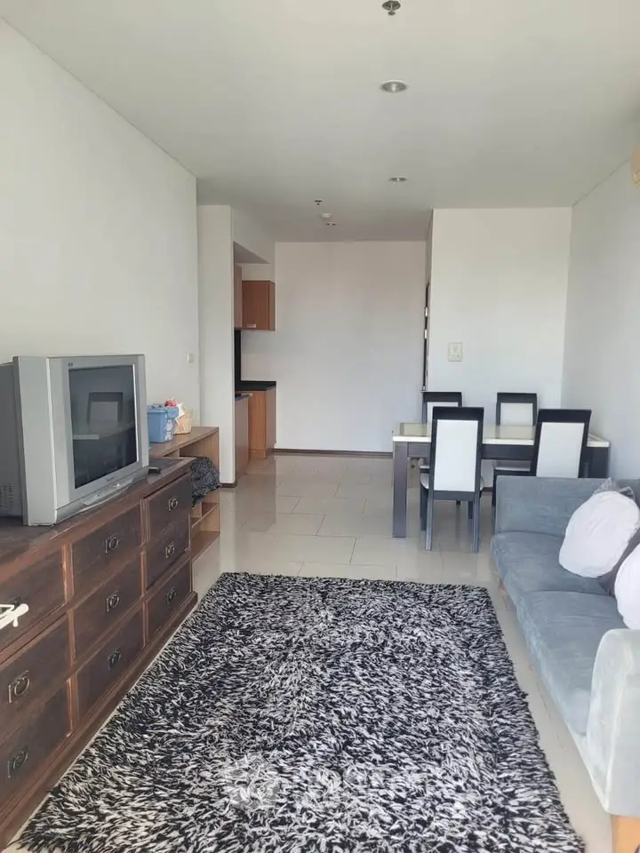 Spacious living room with modern decor and dining area in open layout apartment.