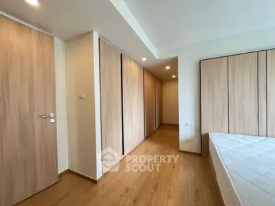 Spacious bedroom with wooden flooring and ample closet space