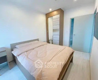 Modern bedroom with cozy bed and stylish wardrobe in a bright apartment.