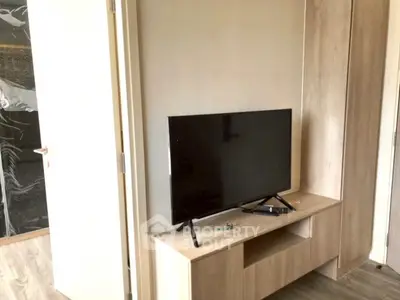 Modern living room with sleek TV setup and stylish wooden furniture