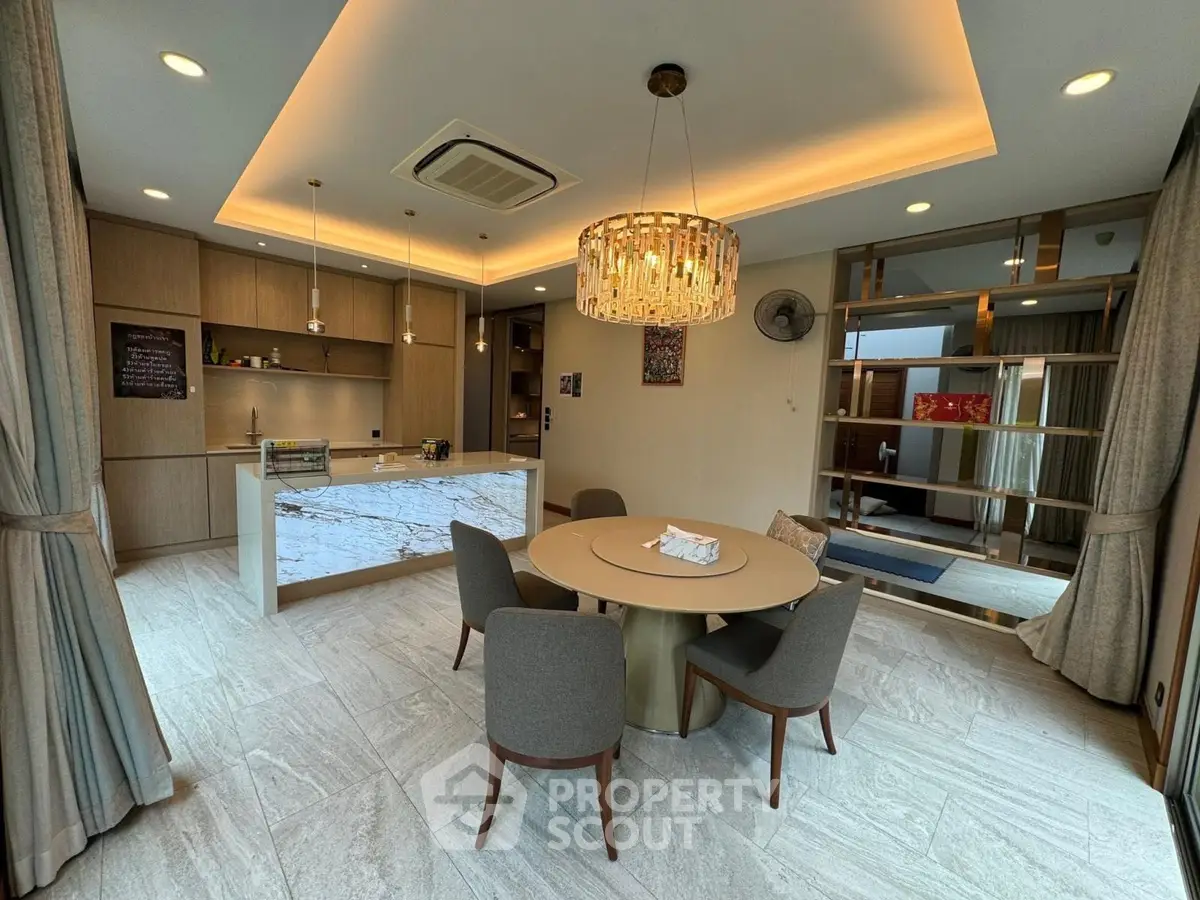 Luxurious open-plan living room with modern kitchen and elegant chandelier