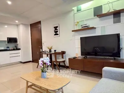 Modern living room with sleek furniture and open kitchen layout in a stylish apartment.
