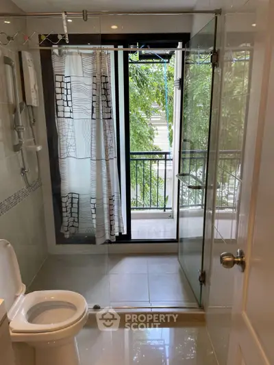 Modern bathroom with glass shower and balcony view, featuring sleek design and natural light.