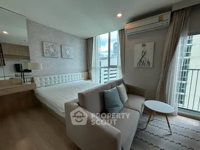 Modern bedroom with stylish decor, featuring a cozy bed, elegant sofa, and large window with city view.