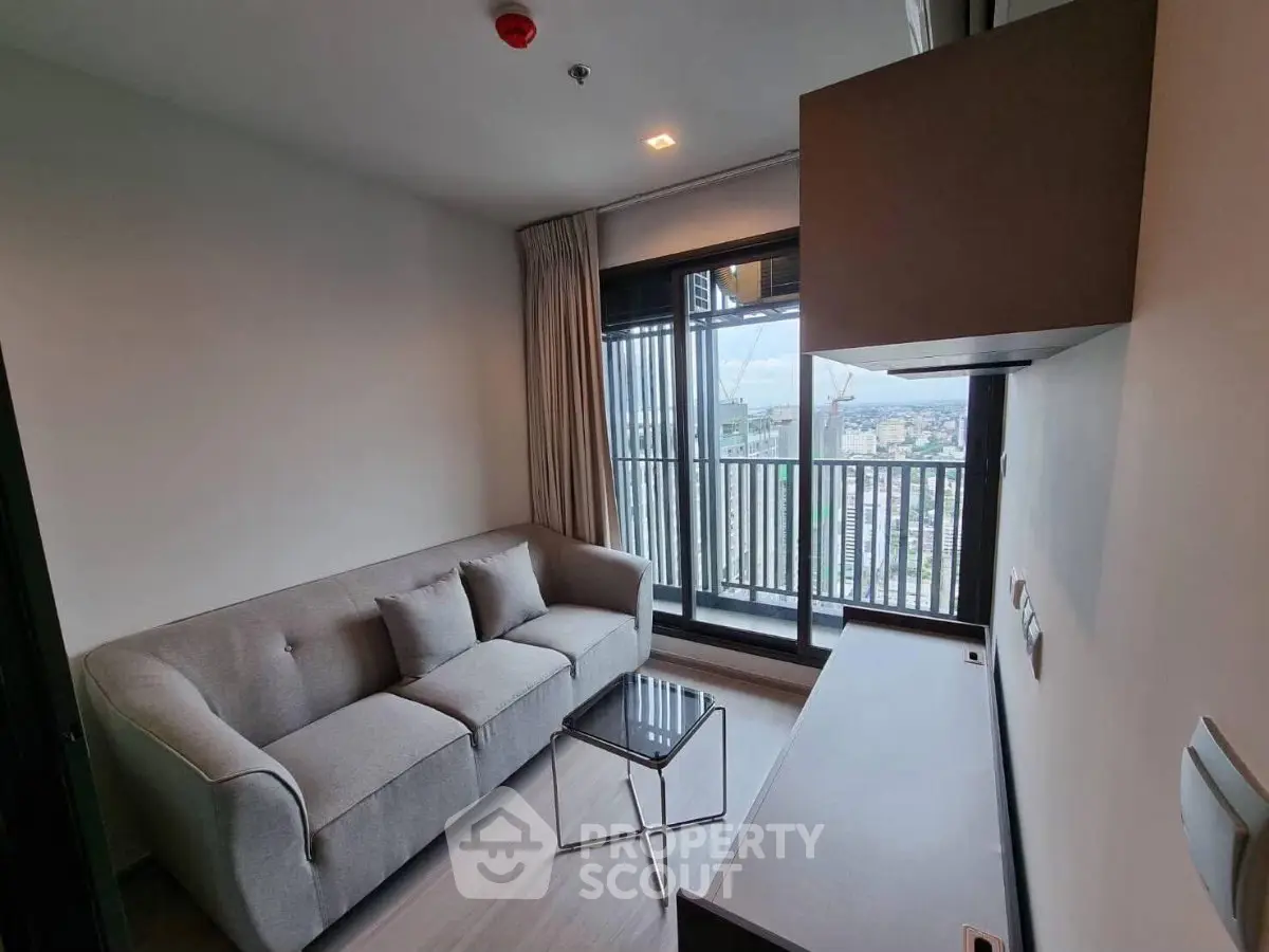 Modern living room with cozy sofa and city view balcony in high-rise apartment.