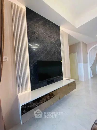 Modern living room with sleek TV unit and marble accent wall