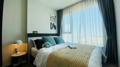 Modern bedroom with large window and stylish decor in high-rise apartment.