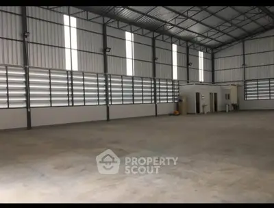 Spacious industrial warehouse with high ceilings and ample natural light.