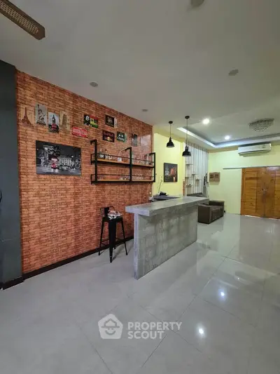 Modern open-plan living room with stylish brick accent wall and sleek bar counter
