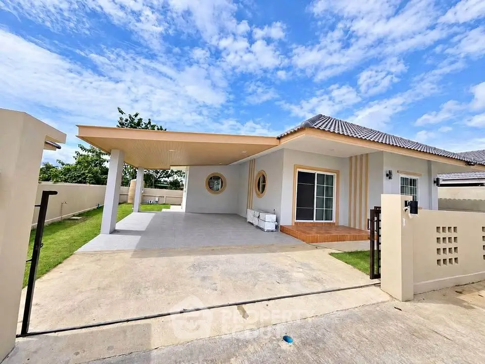 Modern single-story house with spacious driveway and unique circular windows under a clear blue sky.