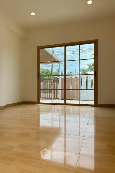 Spacious room with large sliding glass doors and polished tile flooring.