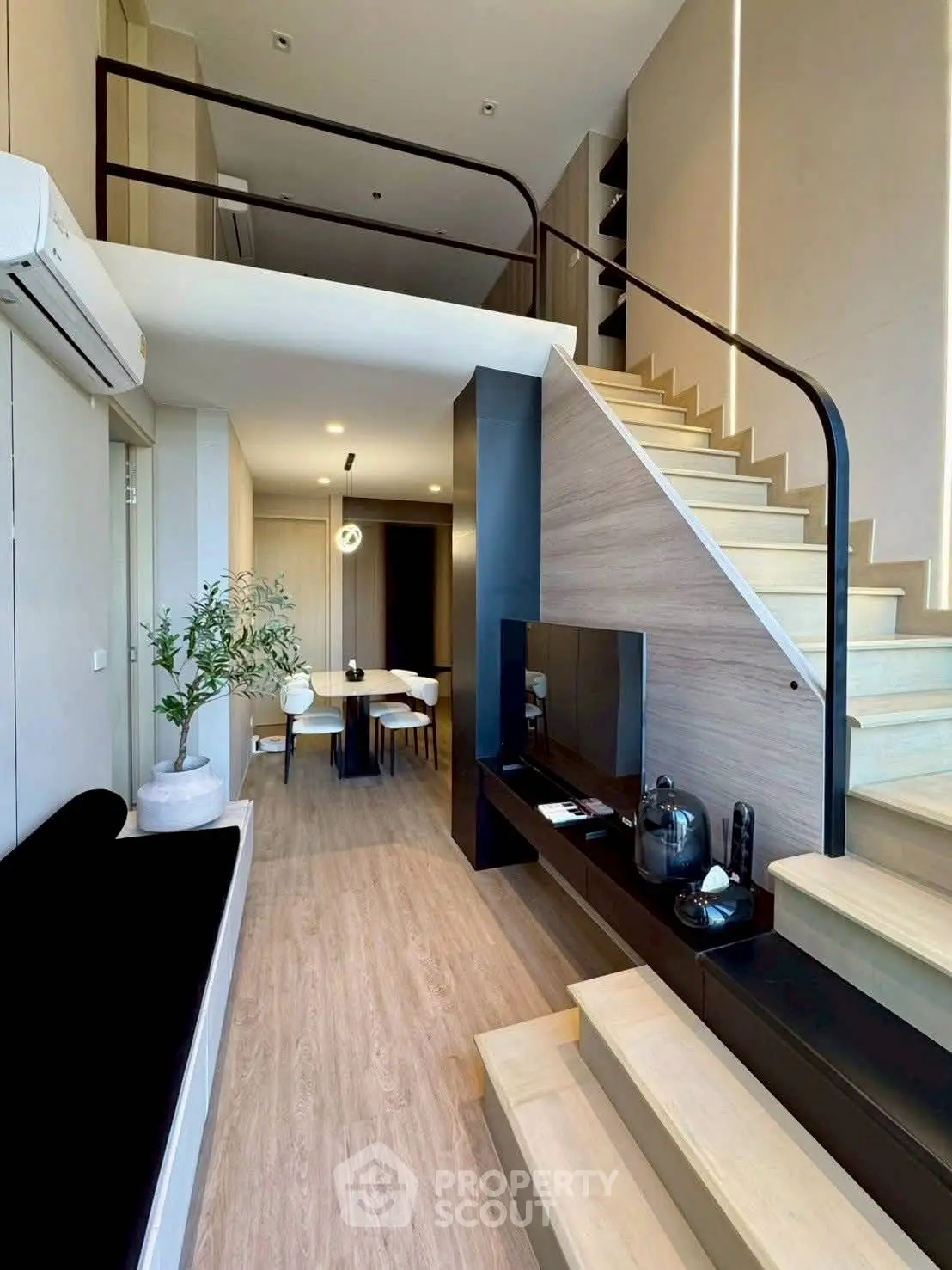 Modern duplex living room with stylish staircase and open dining area