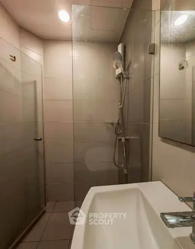 Modern bathroom with sleek shower and bathtub in contemporary apartment.