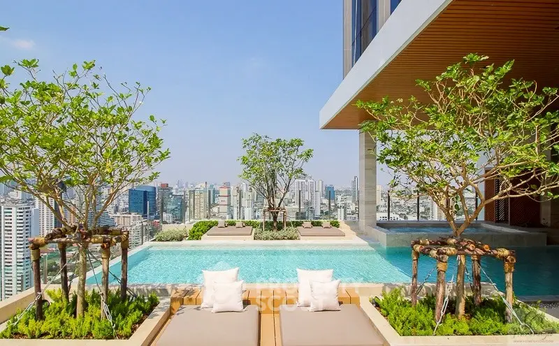Luxurious rooftop pool with stunning city skyline view and lush greenery.