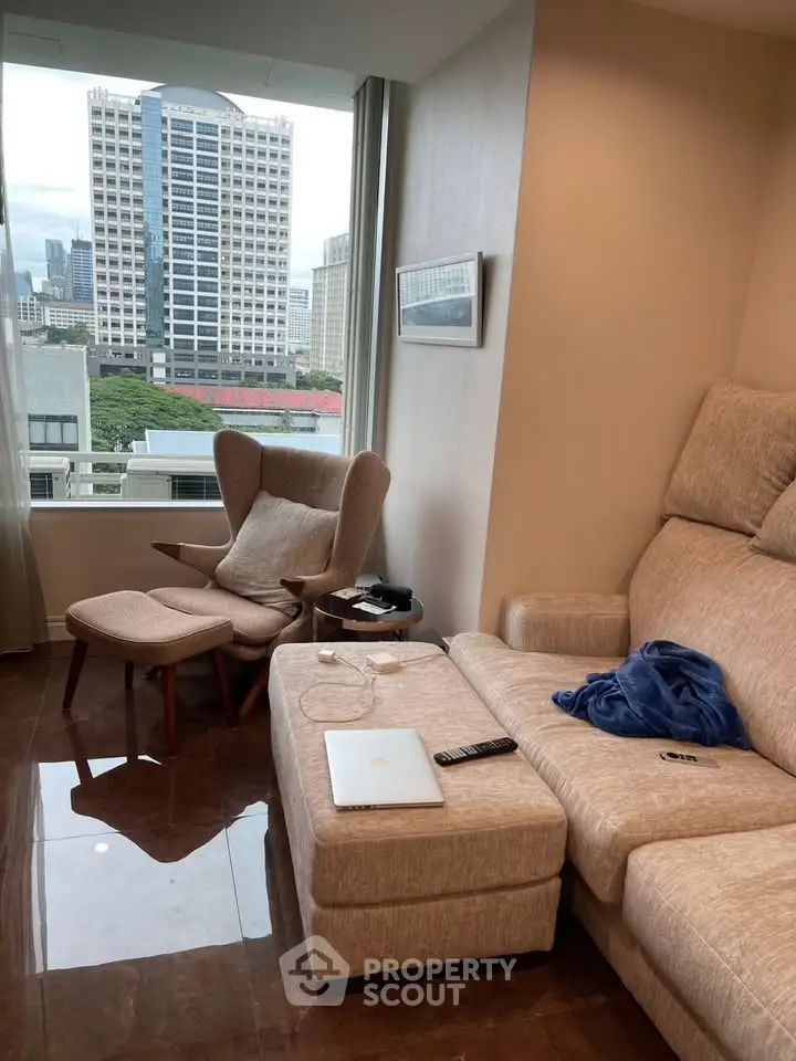 Modern living room with city view, featuring cozy seating and sleek decor.
