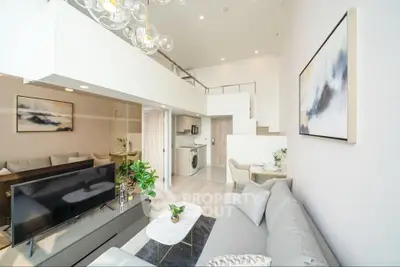 Spacious modern living room with high ceiling and elegant decor in a stylish apartment.