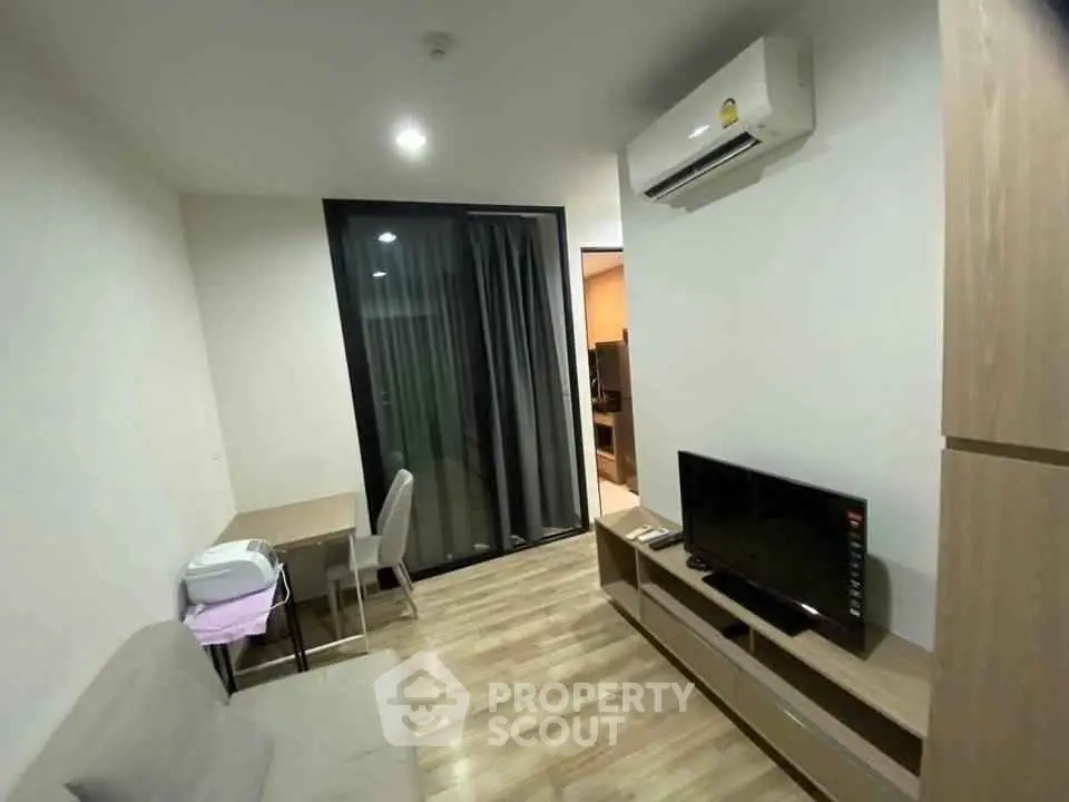 Modern living room with air conditioning and TV, featuring a cozy dining area and sleek wooden flooring.