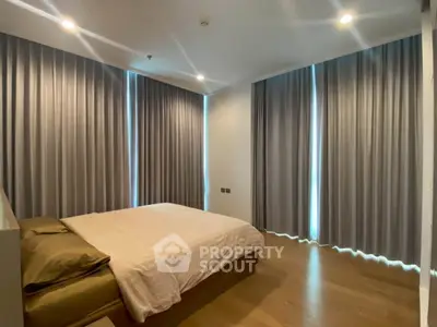 Spacious bedroom with elegant curtains and wooden flooring