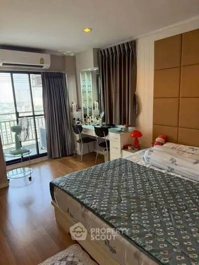 Cozy bedroom with balcony view, modern decor, and ample natural light in urban apartment.