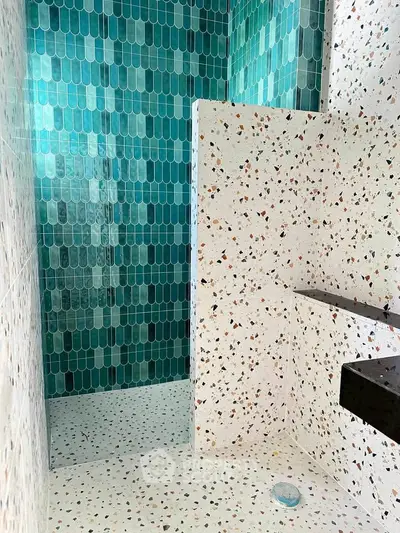 Stylish bathroom with terrazzo tiles and modern green shower design