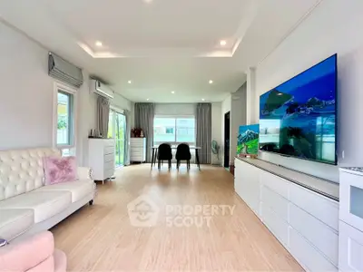 Spacious modern living room with large TV and elegant decor, perfect for family gatherings.