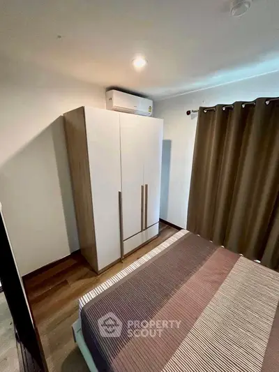 Cozy bedroom with modern wardrobe and stylish curtains, perfect for a restful retreat.