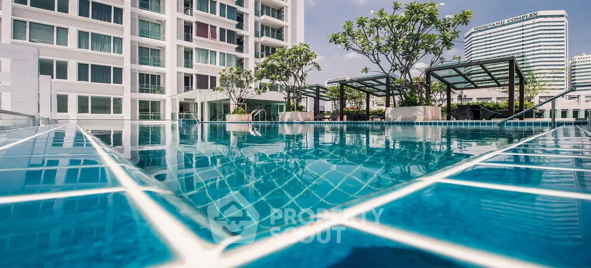 Luxurious rooftop pool with cityscape view in modern high-rise building.