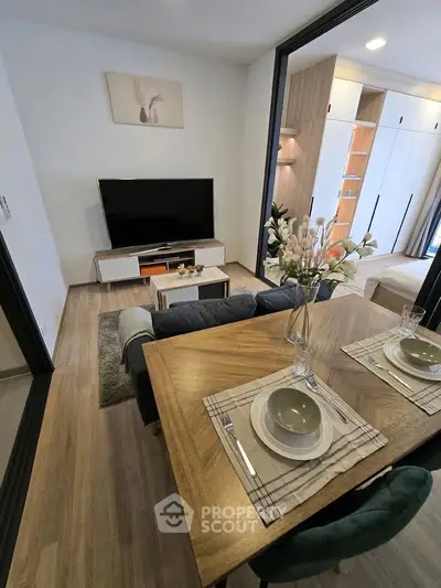 Modern living room with dining area and stylish decor in open layout apartment.