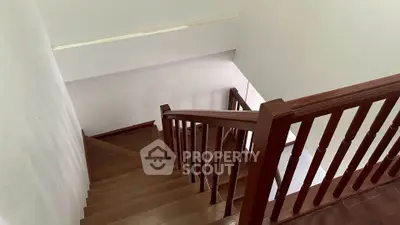 Elegant wooden staircase with polished handrails in a modern home interior.