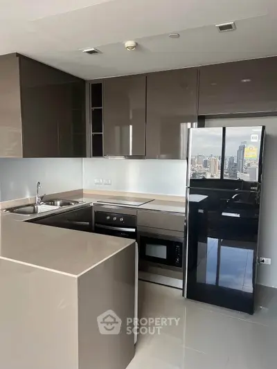Modern kitchen with sleek cabinetry and city view, featuring built-in appliances and glossy finishes.
