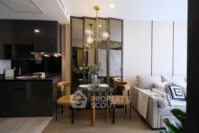 Modern open-layout living room with sleek kitchen and stylish dining area, featuring contemporary furniture and decor.