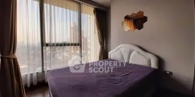 Spacious bedroom with large windows offering stunning city views.