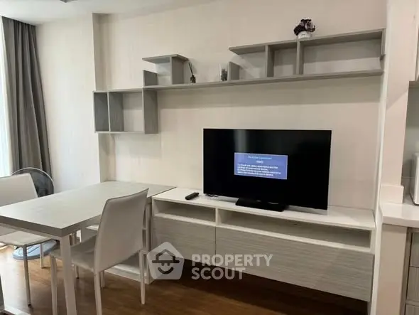 Modern living room with sleek furniture and wall-mounted TV in a stylish apartment.