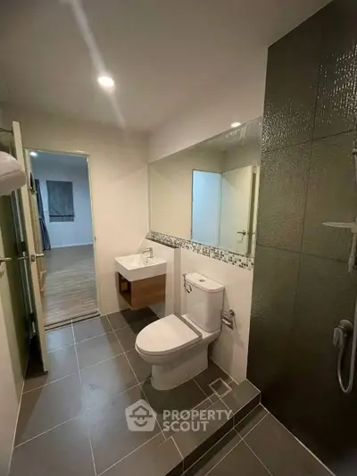 Modern bathroom with sleek design and spacious layout, featuring a large mirror and contemporary fixtures.