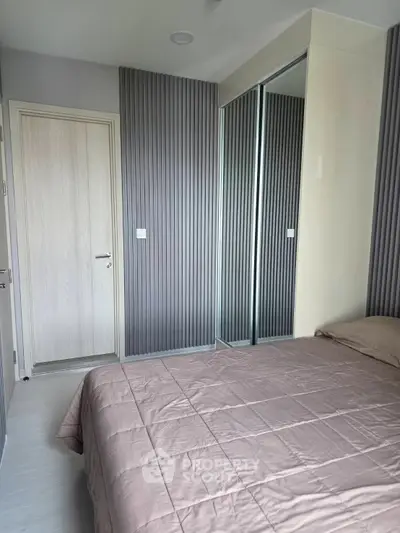 Modern bedroom with sleek design and mirrored closet doors