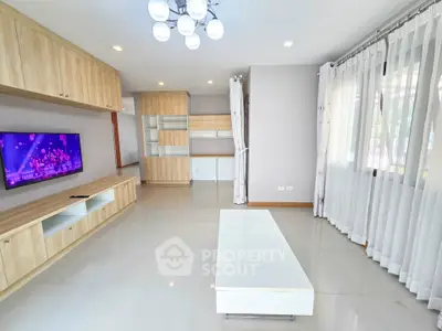 Spacious modern living room with elegant wooden cabinetry and large windows